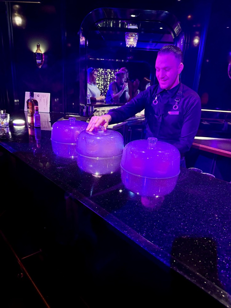 Bartender serving smoked cocktails at Feast for the Senses in The Manor
