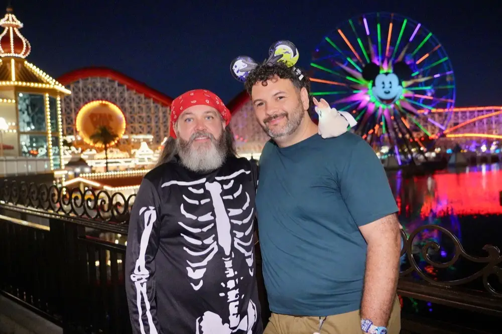 Kieran and Phil in Halloween costumes on Pixar Pier at night