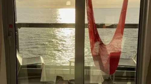 Sunset over the ocean from a Sea Terrace balcony hammock on Brilliant Lady