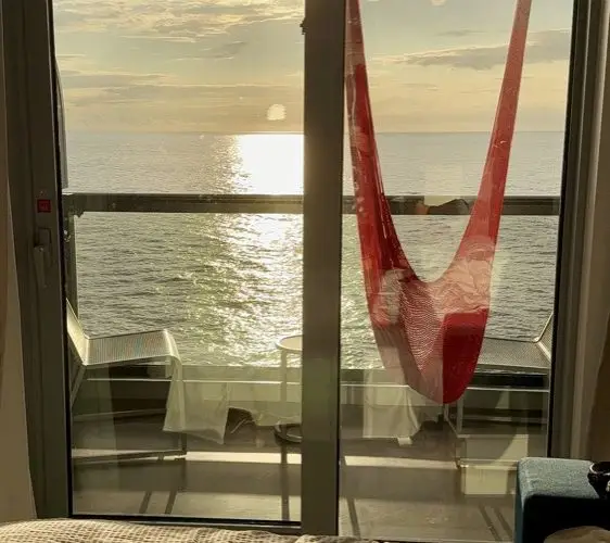 Sunset over the ocean from a Sea Terrace balcony hammock on Brilliant Lady