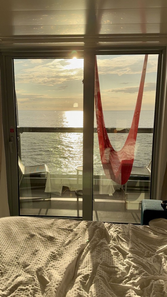 Sunset over the ocean from a Sea Terrace balcony hammock on Brilliant Lady