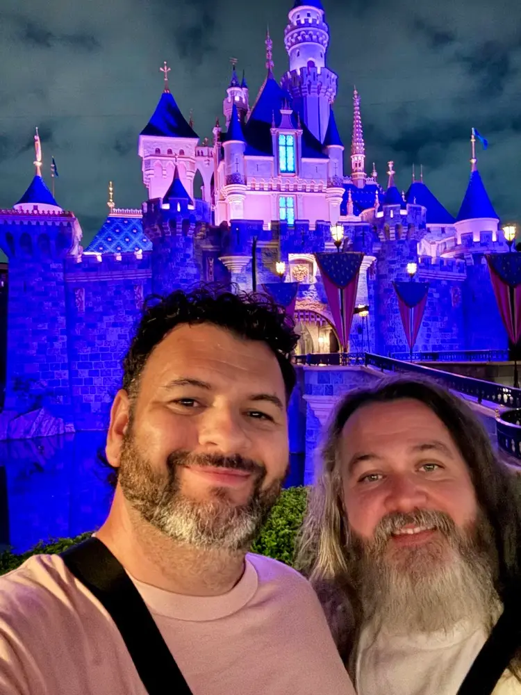 Kieran and Phil in front of Sleeping Beauty Castle at night