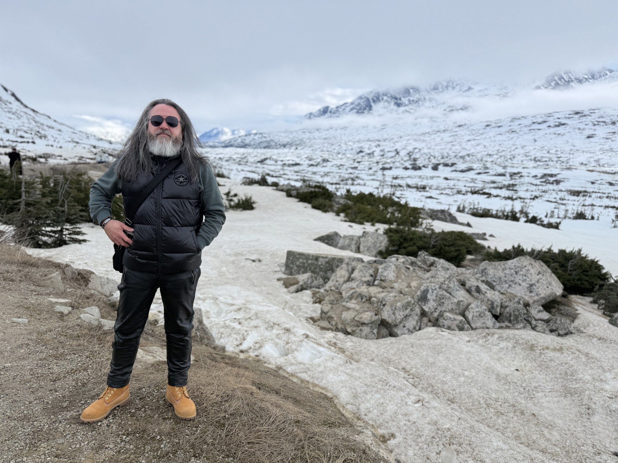 Standing in deep snow at the White Pass summit above Skagway, Alaska