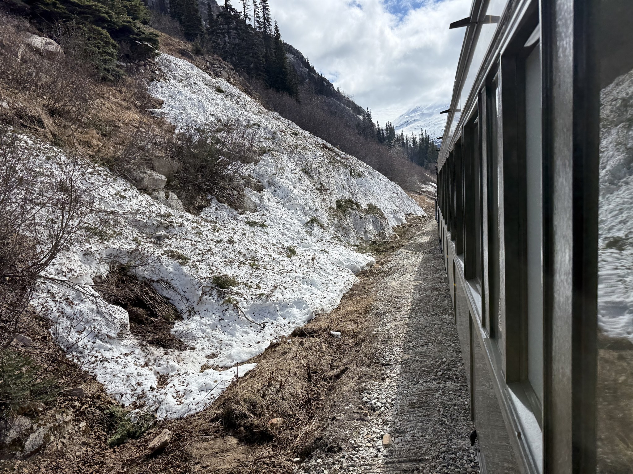 White Pass train running along a snowy mountainside above Skagway