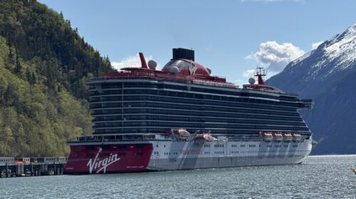 Virgin Voyages Brilliant Lady docked in Alaska beneath snow-capped mountains