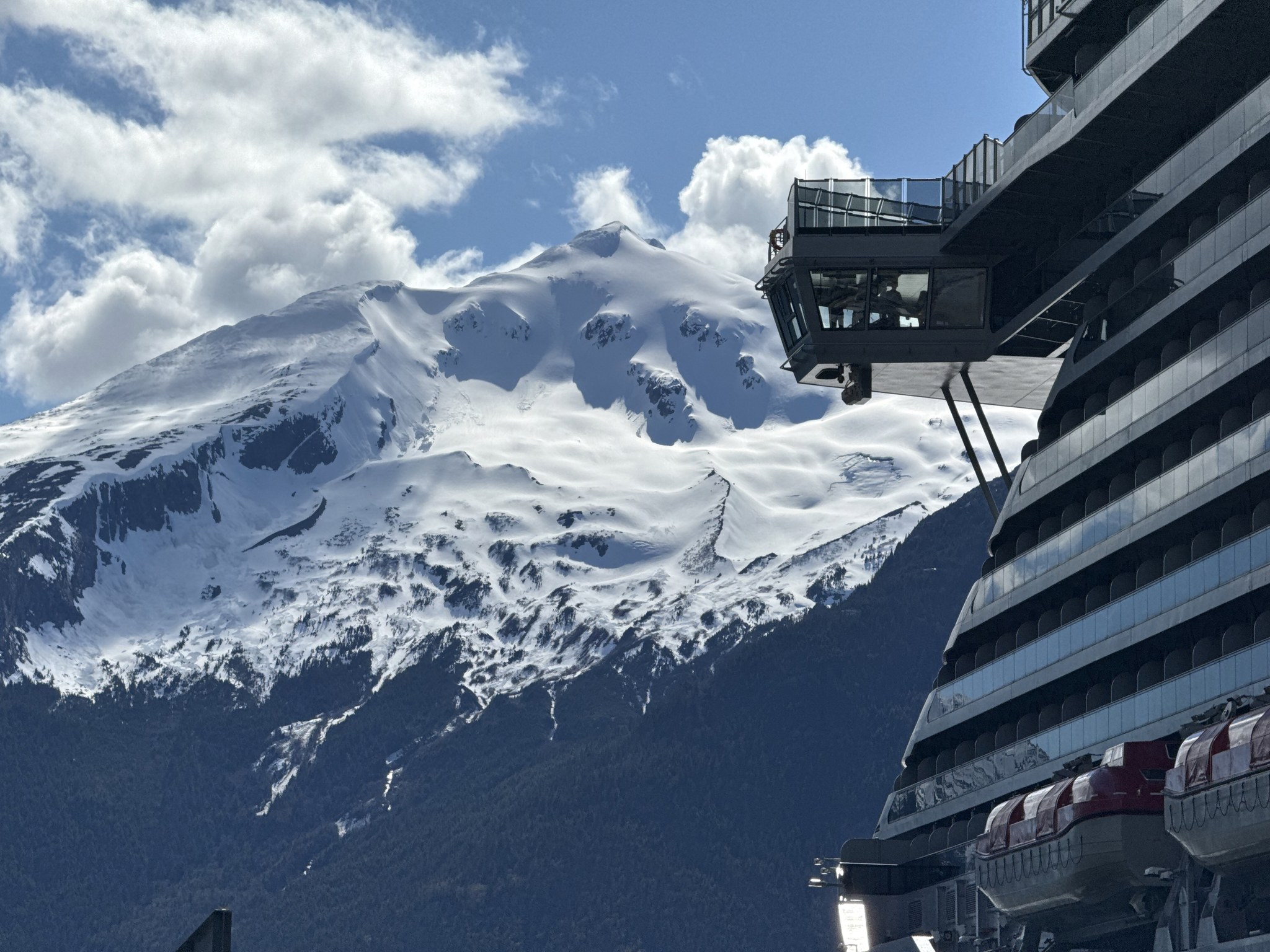 Snow-covered Alaska mountains rising beside Brilliant Lady’s aft decks
