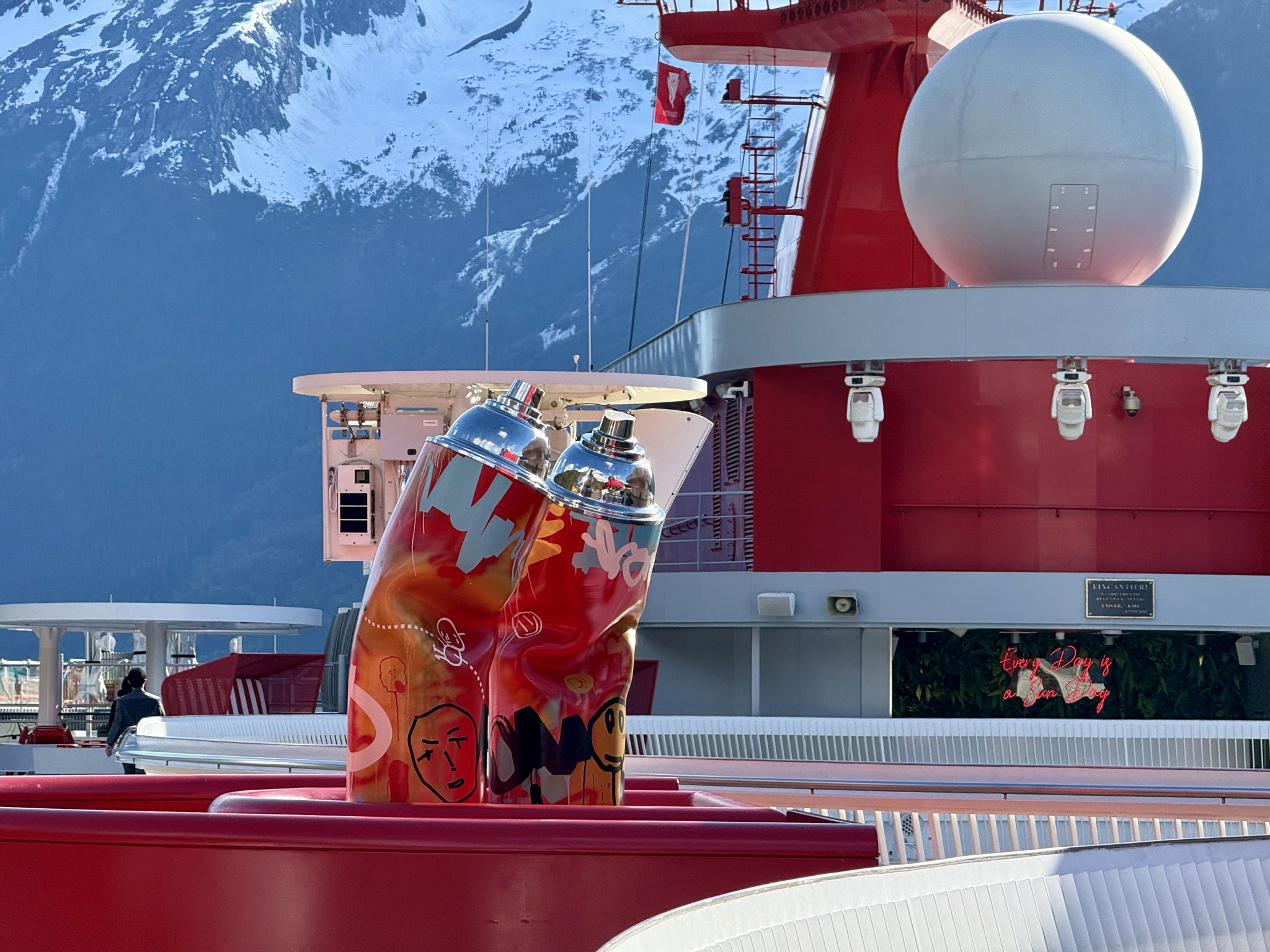 Drinks on deck in front of Brilliant Lady’s red funnel with snowy mountains behind