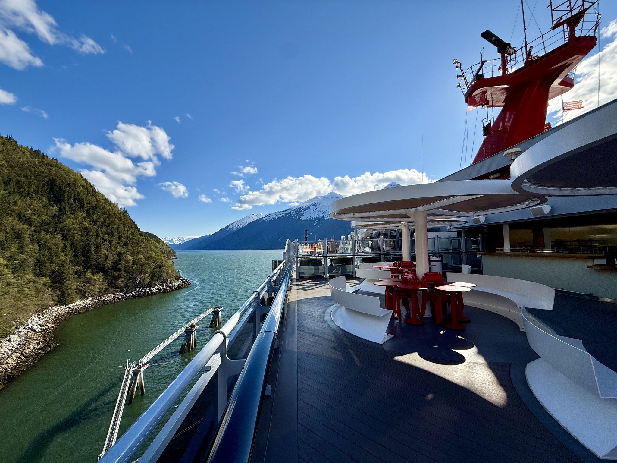Brilliant Lady cruising through a green Alaska fjord on a sunny day
