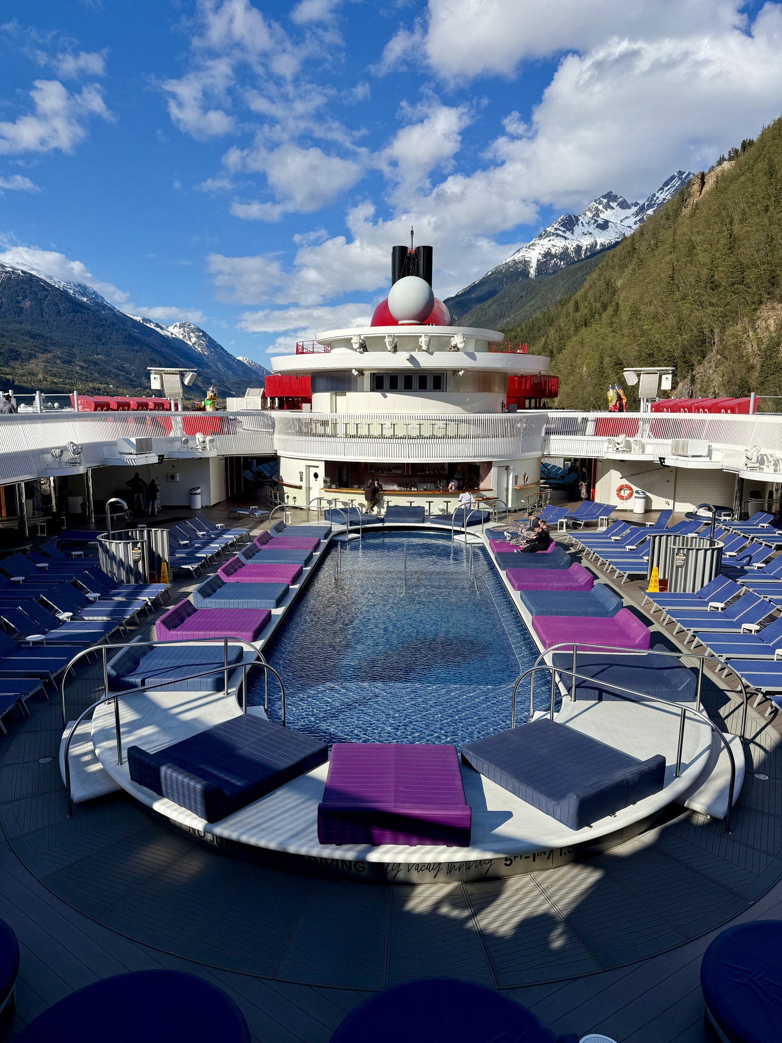 Brilliant Lady’s pool deck with snowy Alaska peaks behind