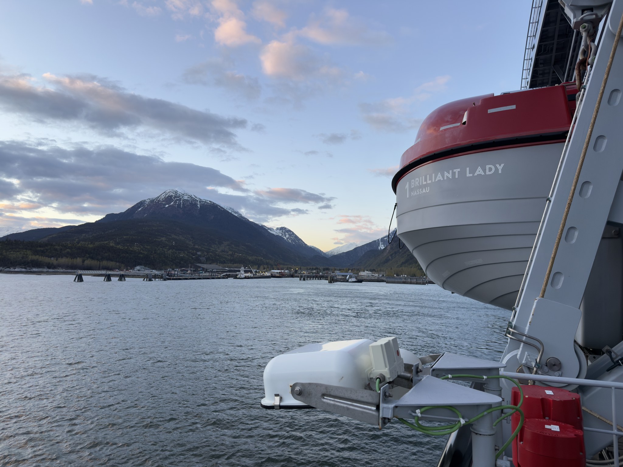 Calm Alaska water and a snowy peak at dusk beside one of Brilliant Lady’s lifeboats