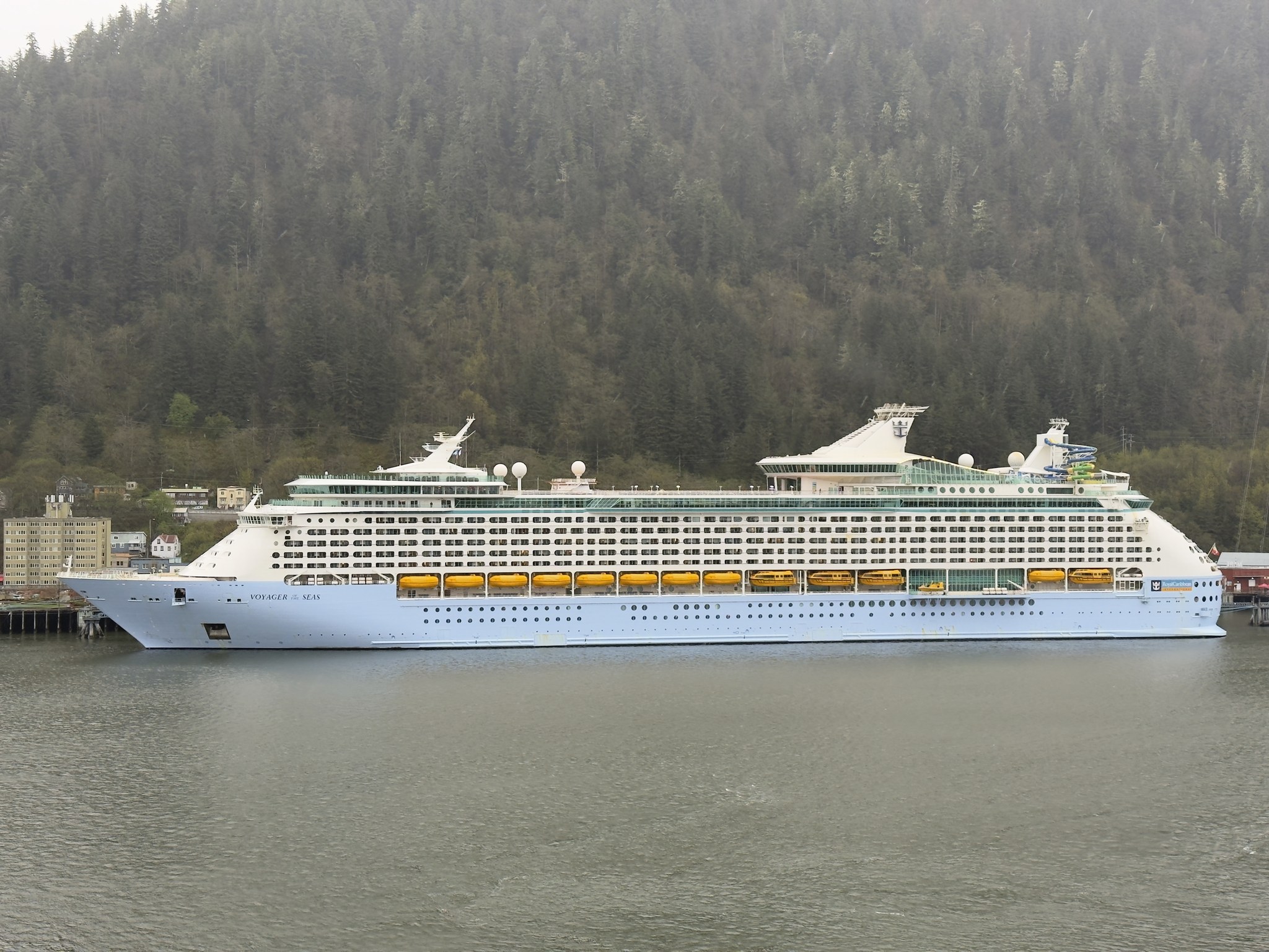 Cruise ship docked below the forested mountains in Juneau