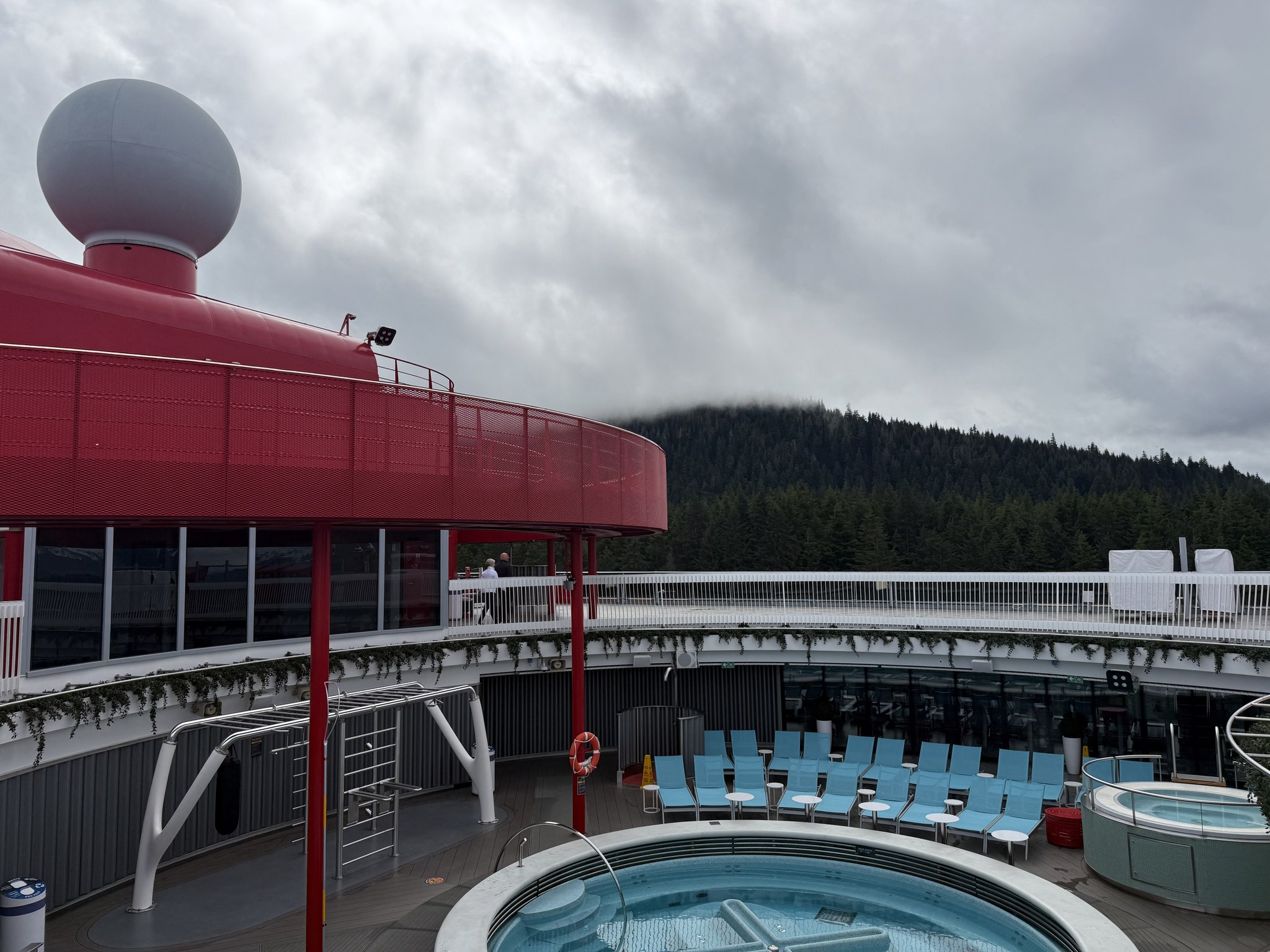 Brilliant Lady’s top deck and hot tub with forested Alaska hills behind