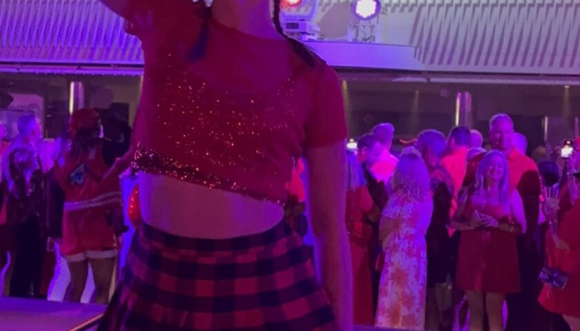 A dancer performing on the pool deck at Scarlet Night on Valiant Lady