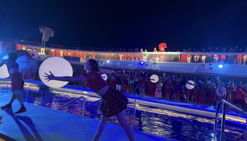 Dancers with giant glowing orbs on the pool deck at Scarlet Night, Valiant Lady