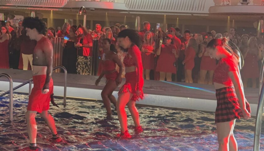 Dancers in the pool with a crowd dressed in red at Scarlet Night, Valiant Lady