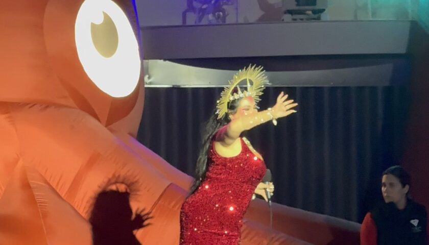 A singer in red sequins in front of the giant octopus at Scarlet Night on Valiant Lady