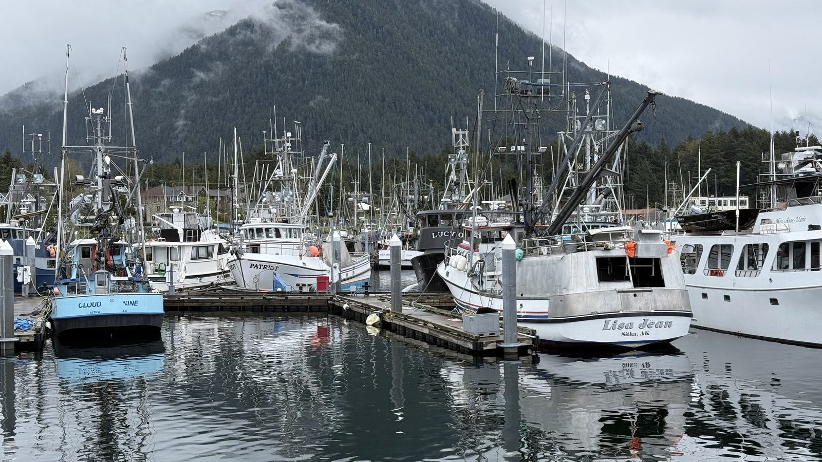 Fishing boats in Sitka harbour with a cloud-topped mountain behind