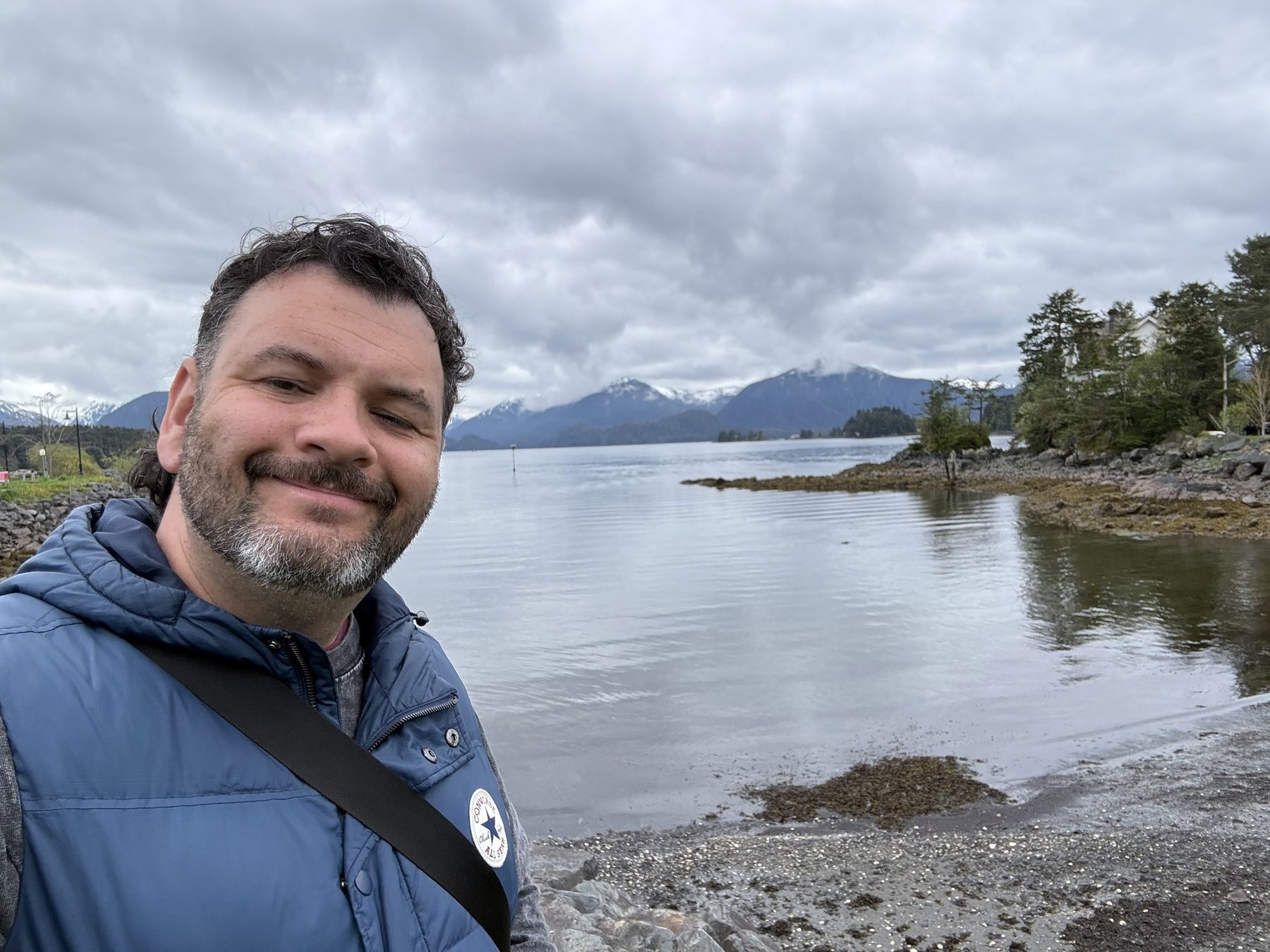 Kieran on the shoreline in Sitka with mountains behind