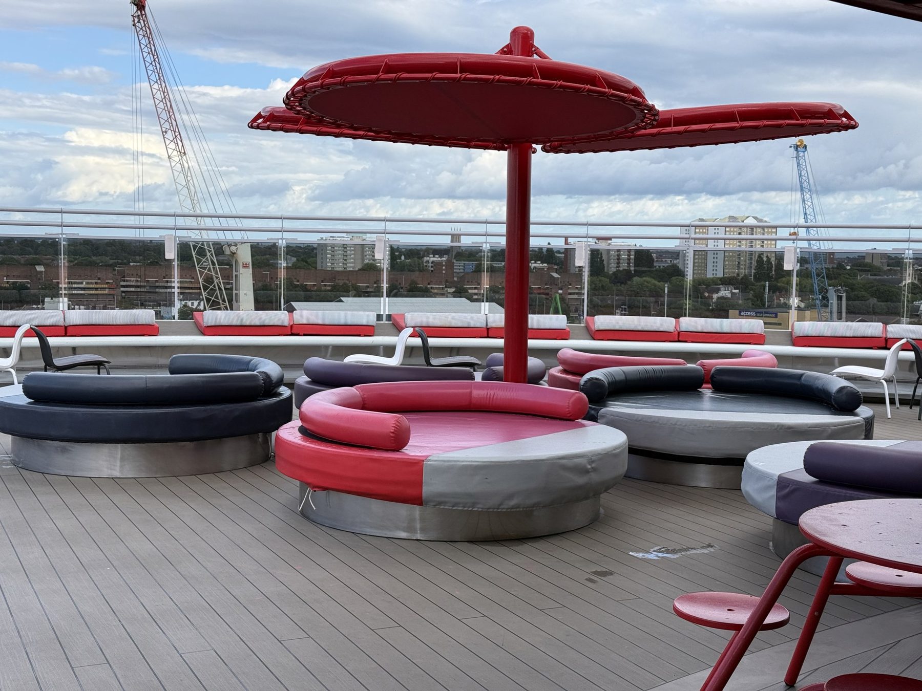Red parasols and lounge seating on an open deck of Valiant Lady