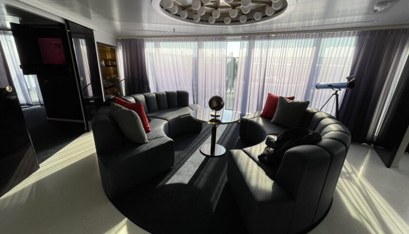 Living room with a curved sofa in a Virgin Voyages RockStar suite