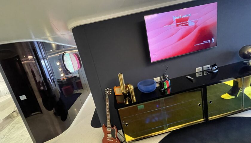 Lounge with TV, guitar and bar in a Virgin Voyages Massive Suite