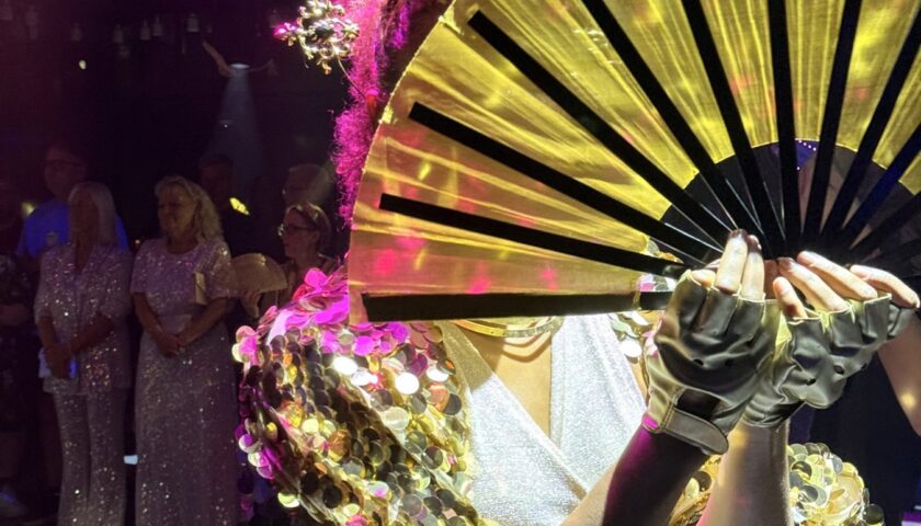 A We Fancy performer with a gold fan on Valiant Lady
